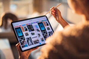 Una persona usa una tableta digital con un lápiz en un ambiente cálido y acogedor.